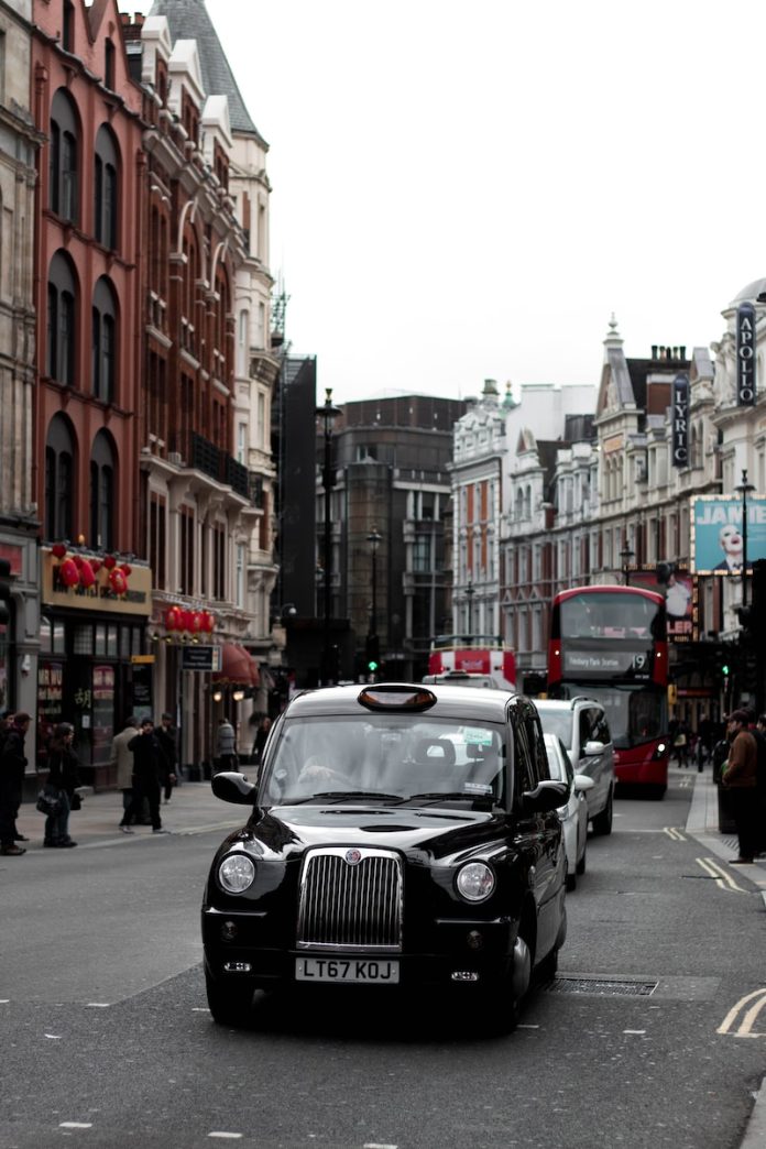 black cab on road during daytime