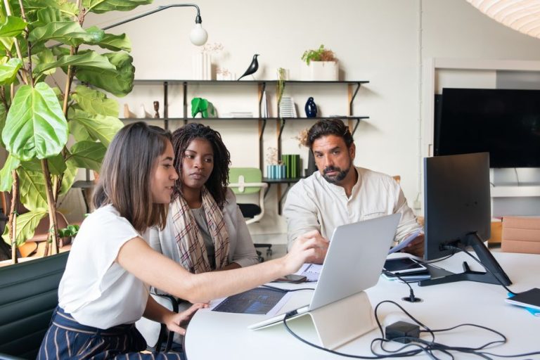 Small business team security review Small business team reviewing work together on a laptop in an office