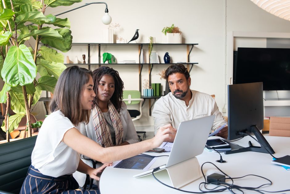 Small business team security review Small business team reviewing work together on a laptop in an office