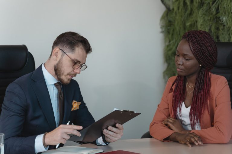 Recruiter reviewing a candidate profile on a clipboard during a legal job interview