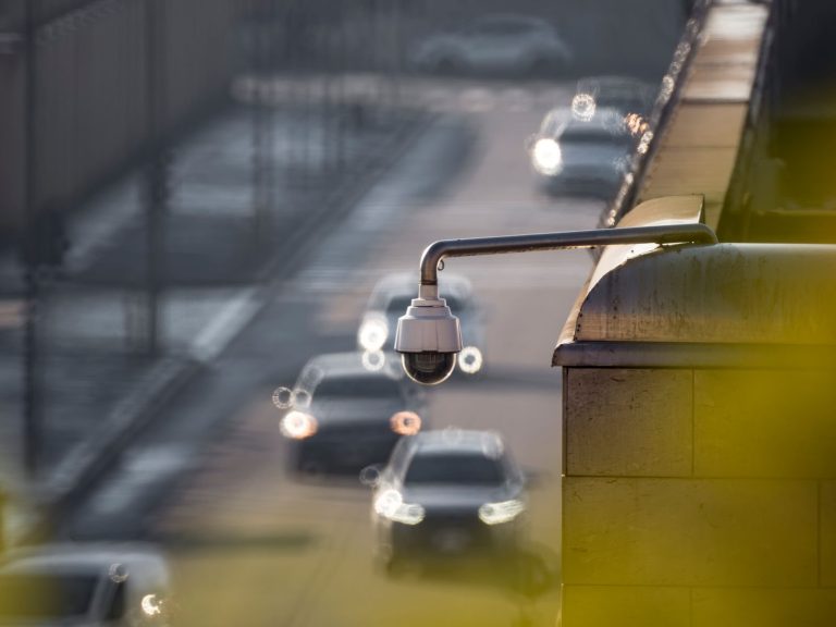 Street camera mounted above a busy road with traffic passing below