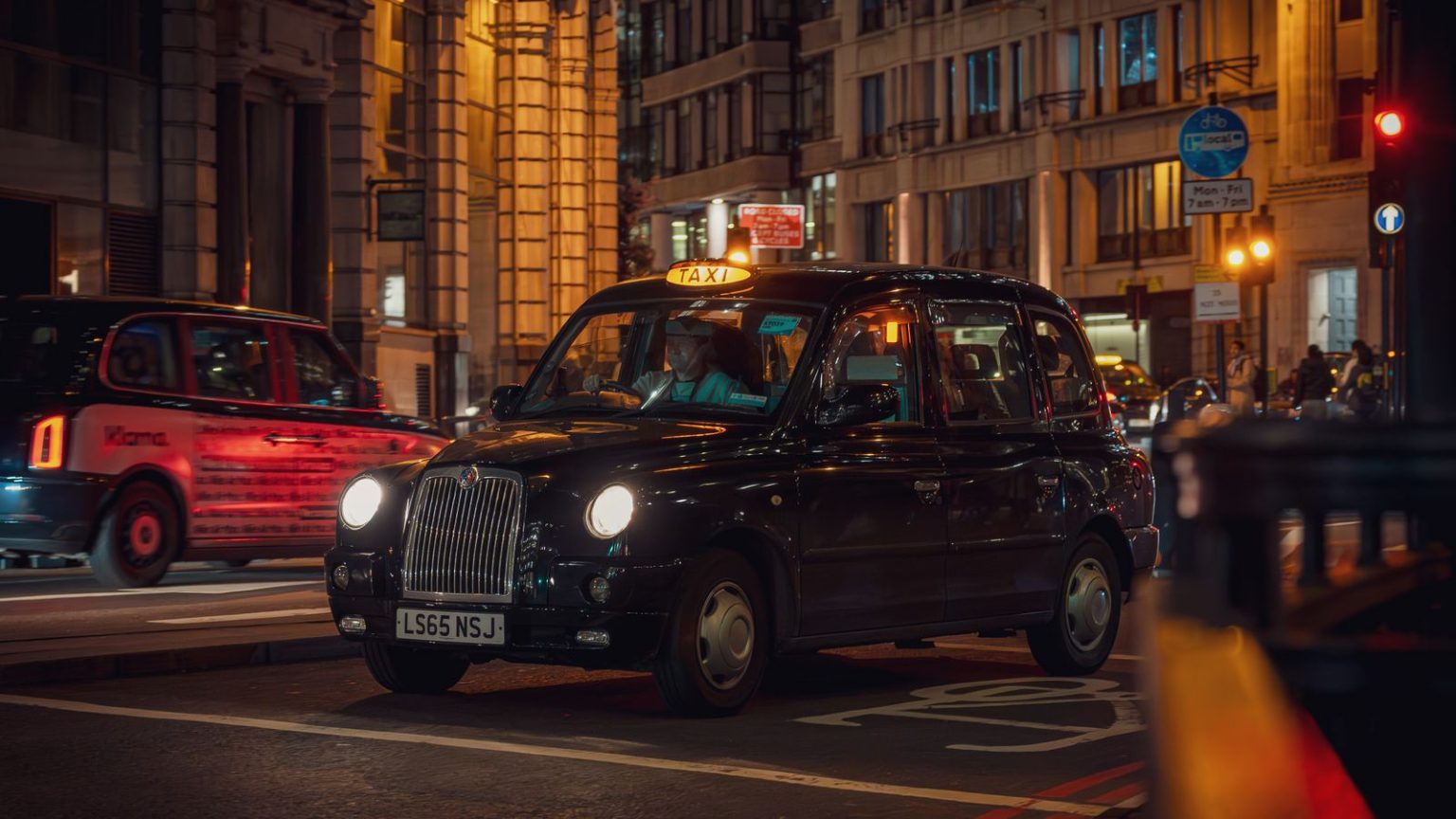 A black taxi on a London street at night Law News|Home