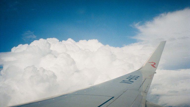 Aircraft wing above white clouds Aircraft wing above white clouds