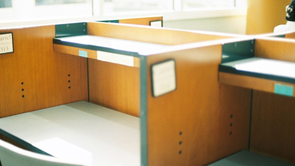 Empty wooden desks in a sunlit open-plan office