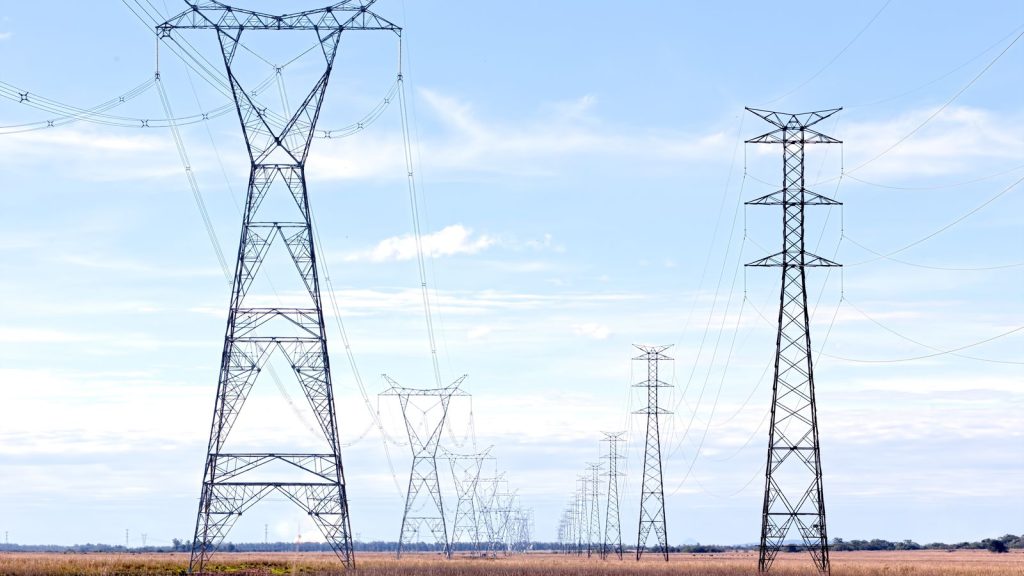 High voltage electricity pylons across an open field
