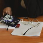 Eyeglasses and a book on a wooden desk