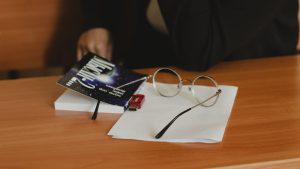 Eyeglasses and a book on a wooden desk